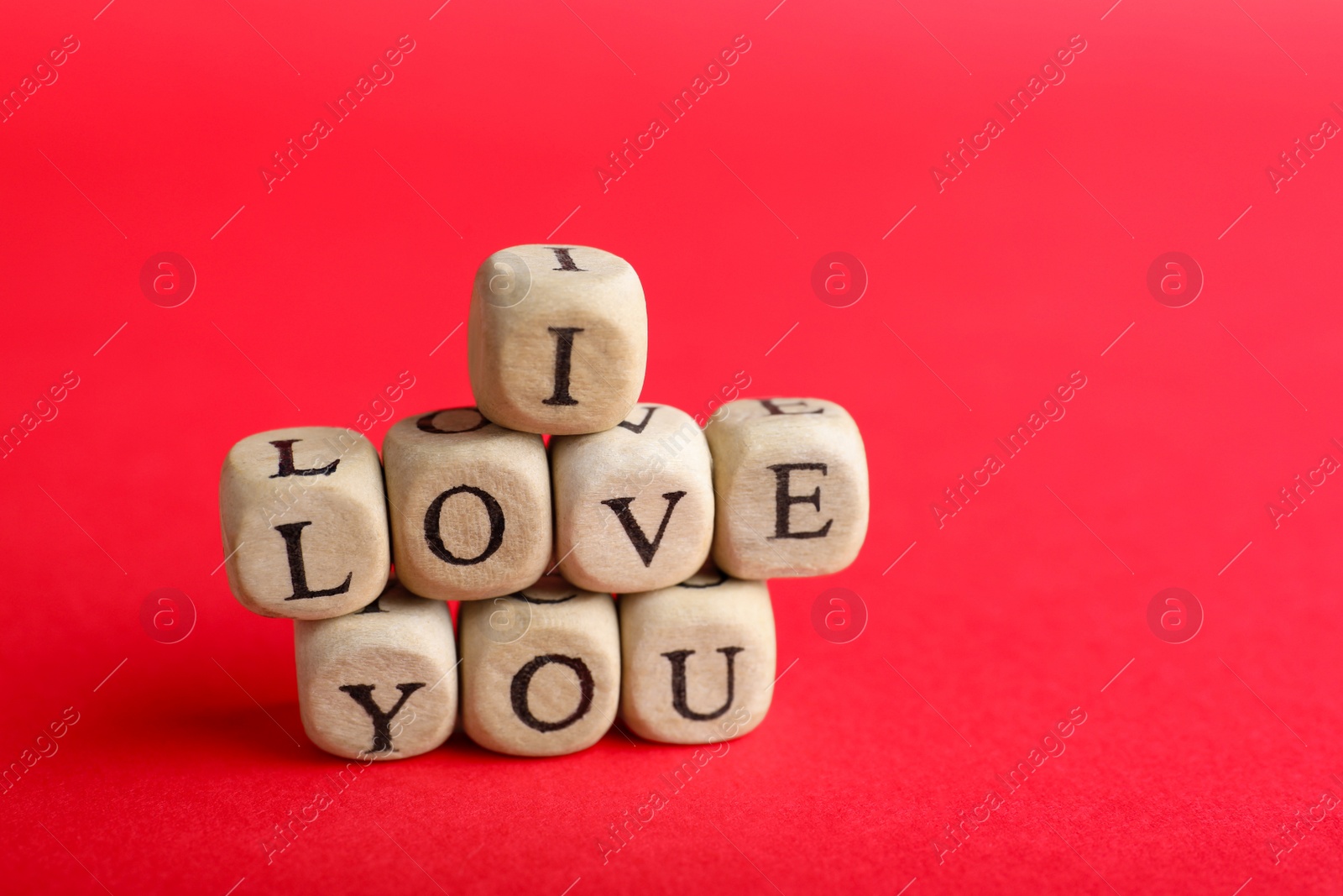 Photo of Cubes with words I Love You on red background. Space for text