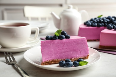 Photo of Plate with piece of tasty blueberry cake served on light table