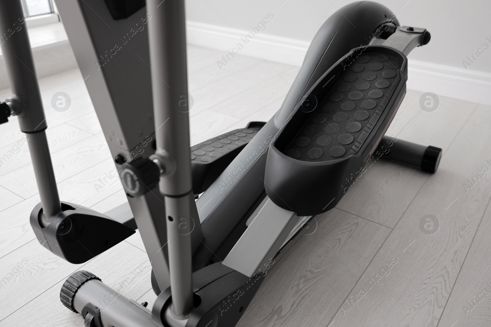 Photo of Modern elliptical machine cross trainer on floor indoors