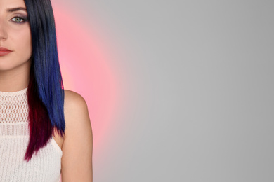Young woman with bright dyed hair on color background, closeup. Space for text