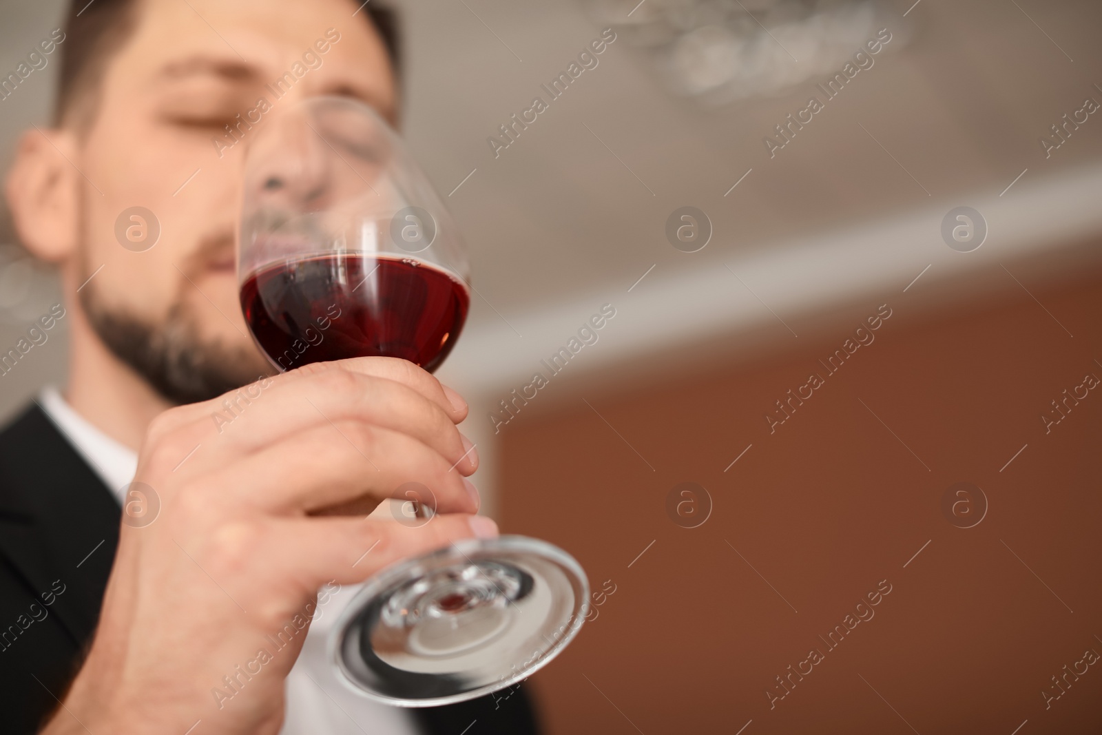 Photo of Young man with glass of wine indoors