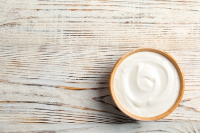 Bowl with yummy yogurt on wooden table