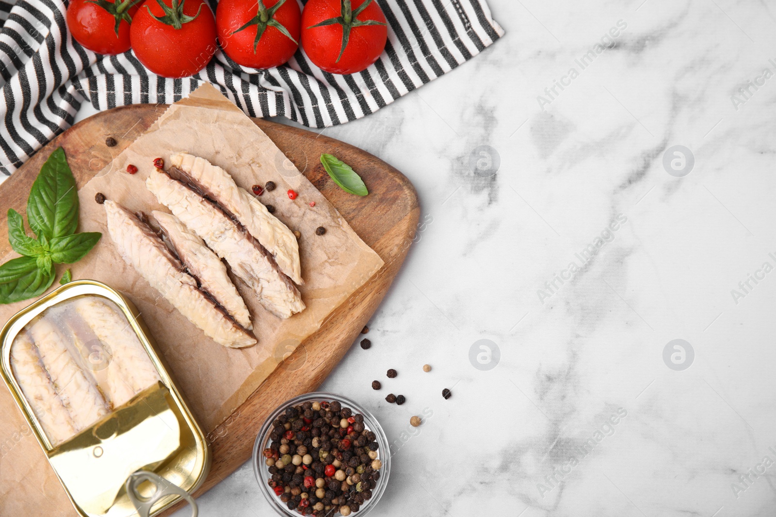 Photo of Canned mackerel fillets served on white marble table, flat lay. Space for text