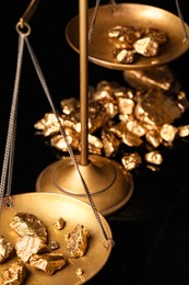 Vintage scales with gold nuggets on black background