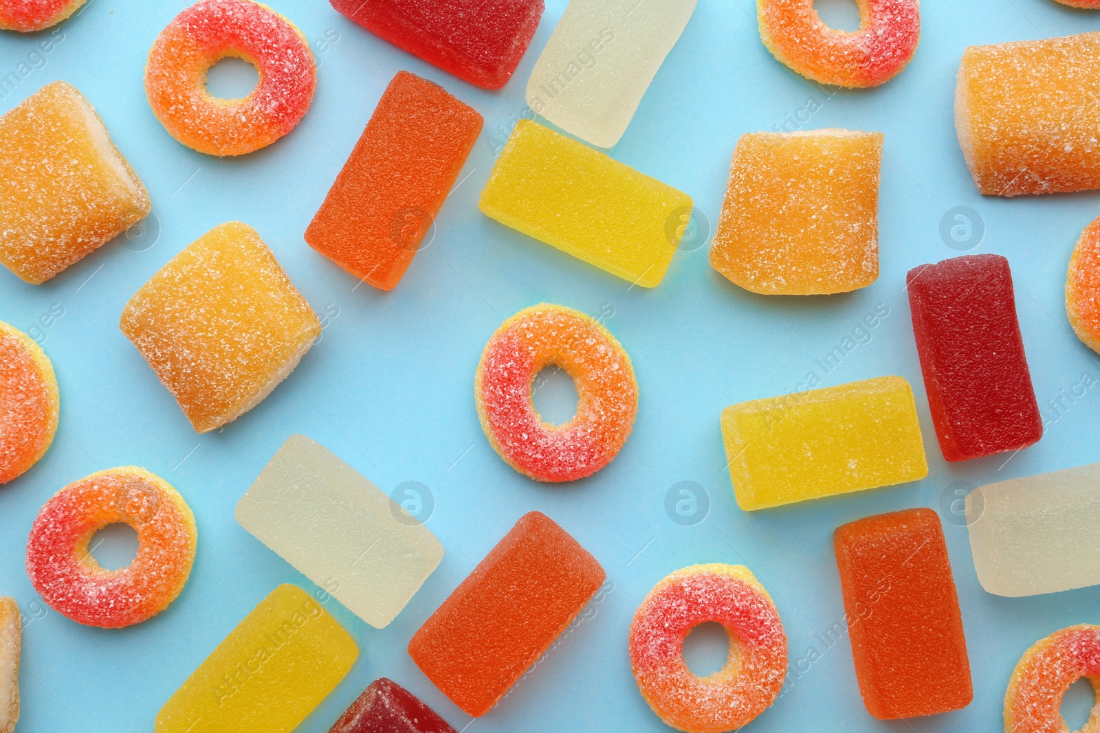 Photo of Different tasty jelly candies on color background, flat lay