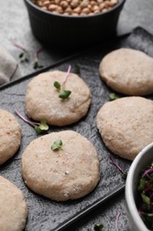 Raw vegan nuggets and spices on slate plate, closeup