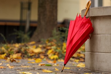 Photo of Autumn atmosphere. One red umbrella on city street, space for text