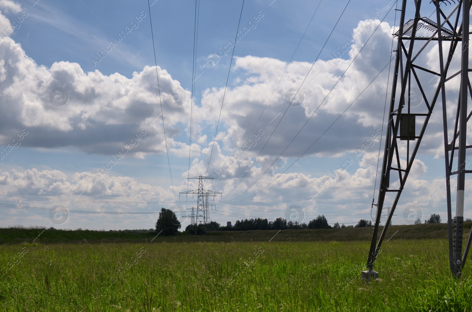 Photo of Modern high voltage towers in field on sunny day