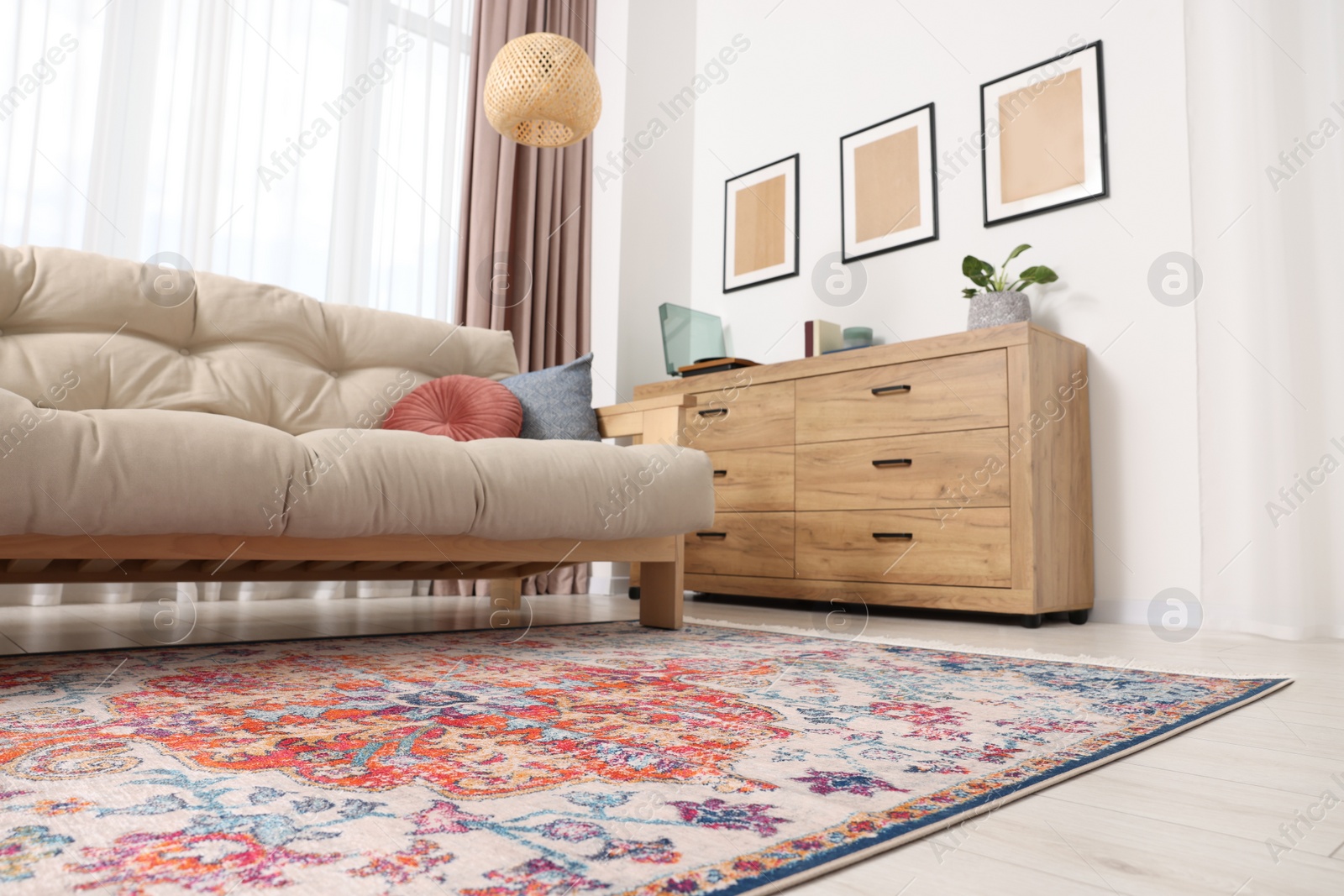 Photo of Beautiful rug, sofa and chest of drawers indoors, low angle view