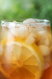 Photo of Delicious iced tea in glass outdoors, closeup