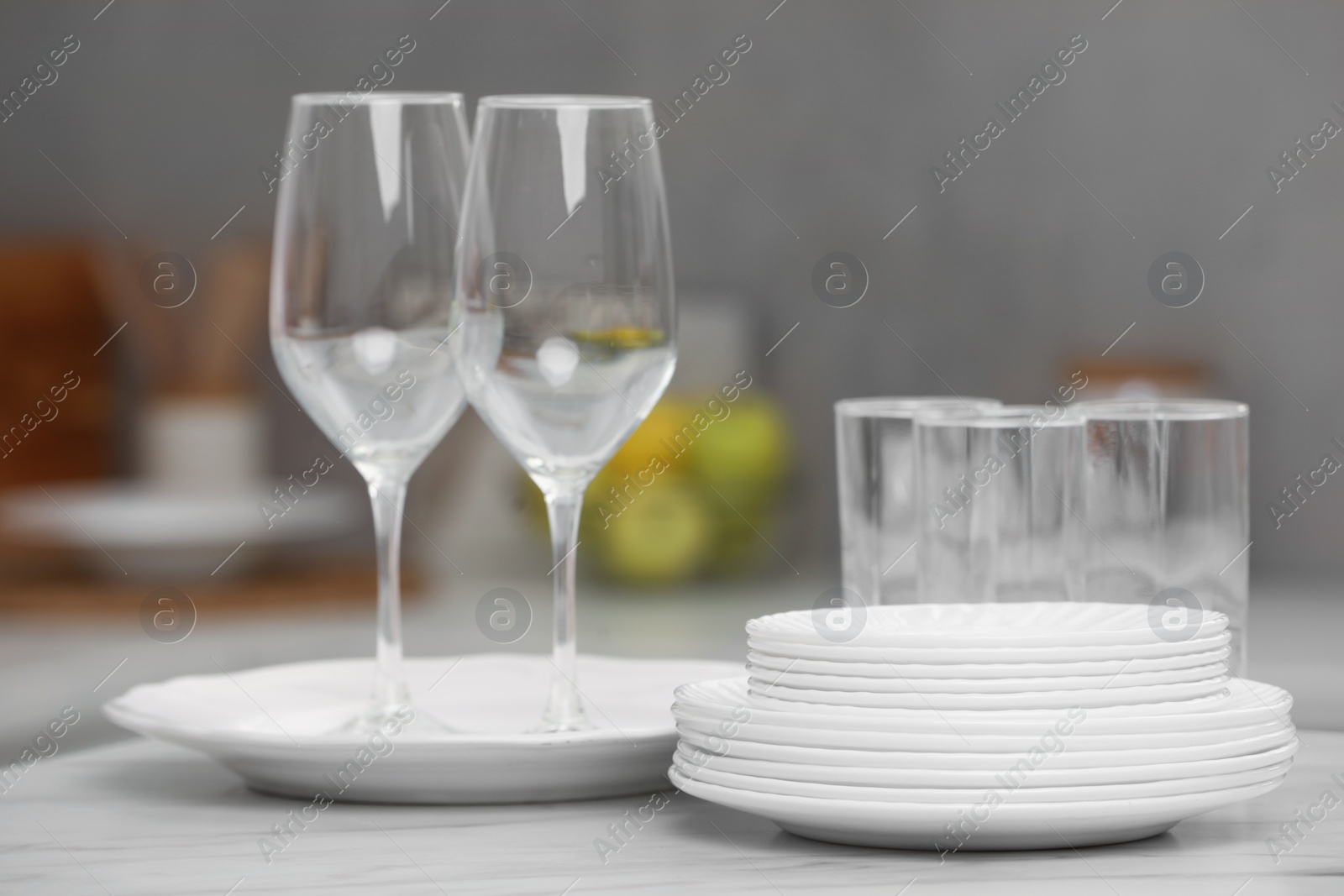 Photo of Clean dishes on light table in kitchen