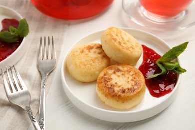 Photo of Delicious cottage cheese pancakes with jam and mint on white wooden table