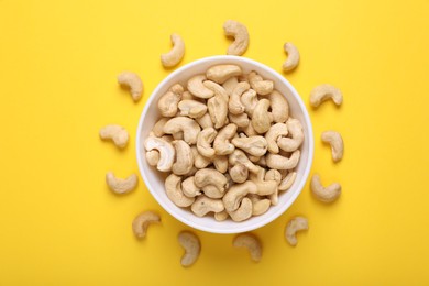 Photo of Tasty cashew nuts on yellow background, top view