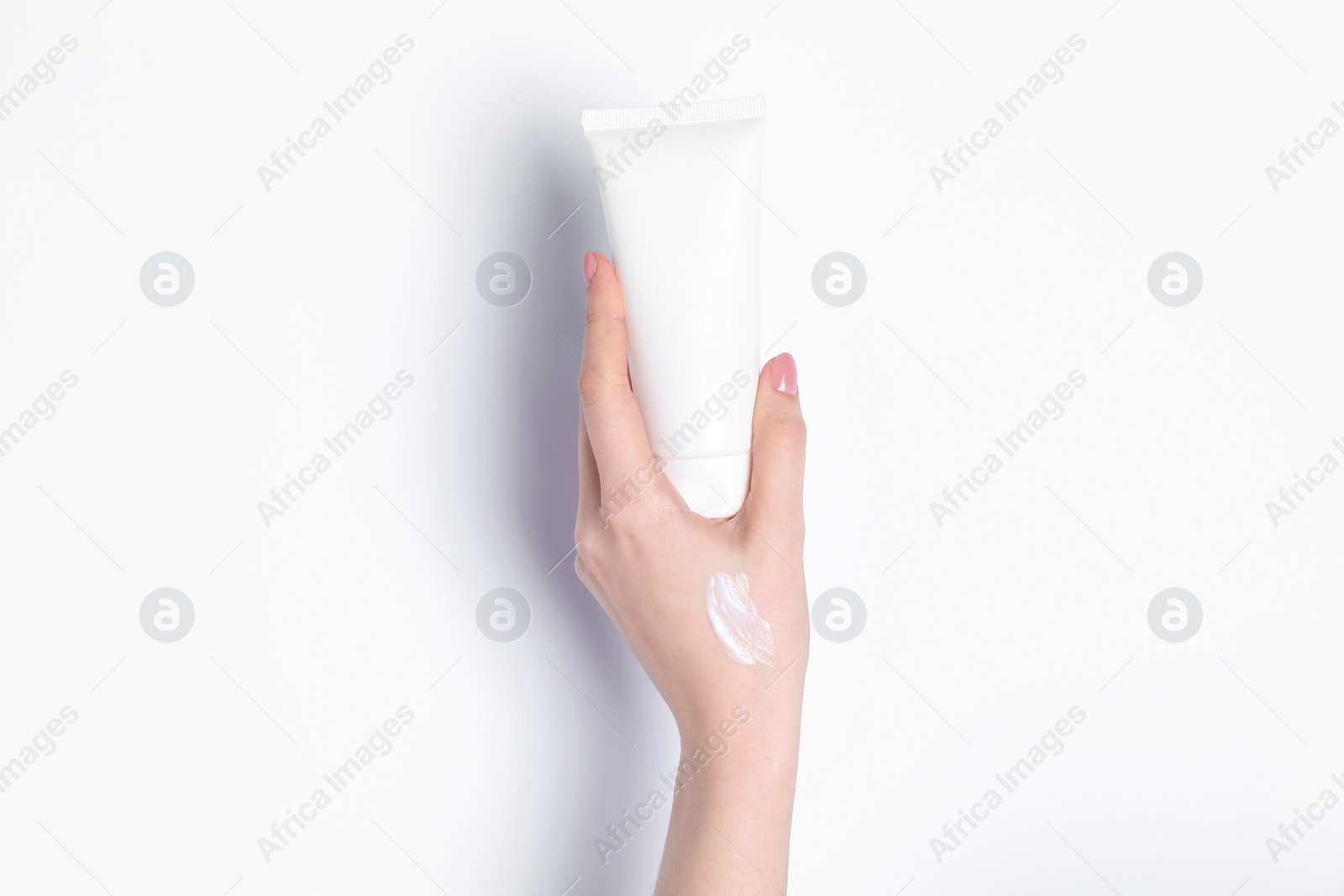 Photo of Woman with tube of cream on white background, closeup