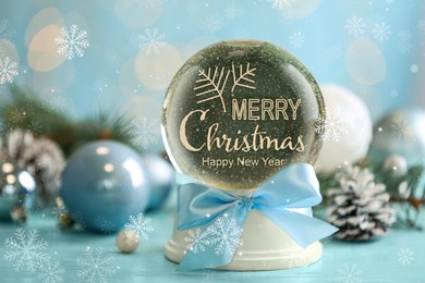 Image of Beautiful snow globe with phrase Merry Christmas and decor on light blue table, closeup