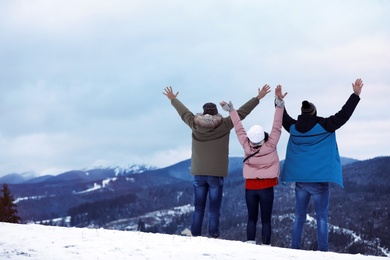 Friends enjoying mountain landscape, space for text. Winter vacation