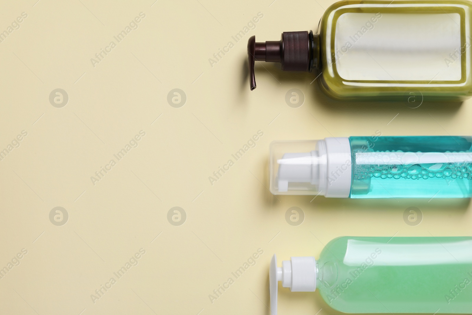 Photo of Different cleansers on beige background, flat lay with space for text. Cosmetic product