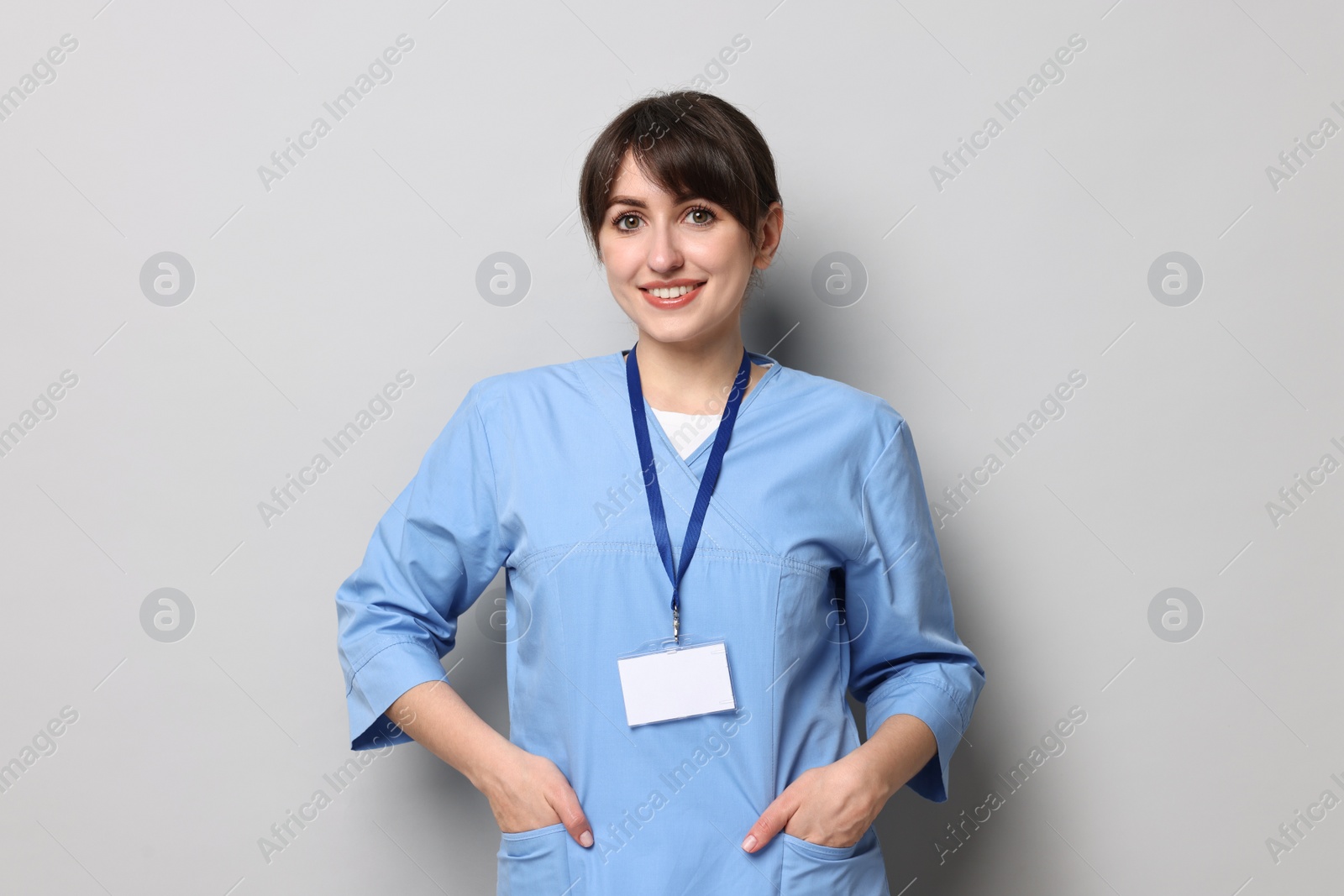 Photo of Portrait of smiling medical assistant on grey background