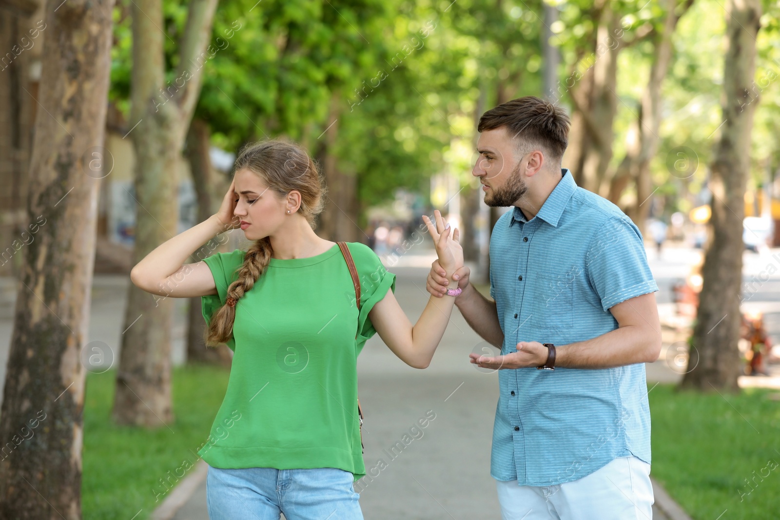 Photo of Young couple arguing on street. Problems in relationship