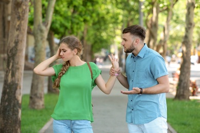 Photo of Young couple arguing on street. Problems in relationship