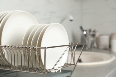 Photo of Drying rack with clean dishes on kitchen counter. Space for text