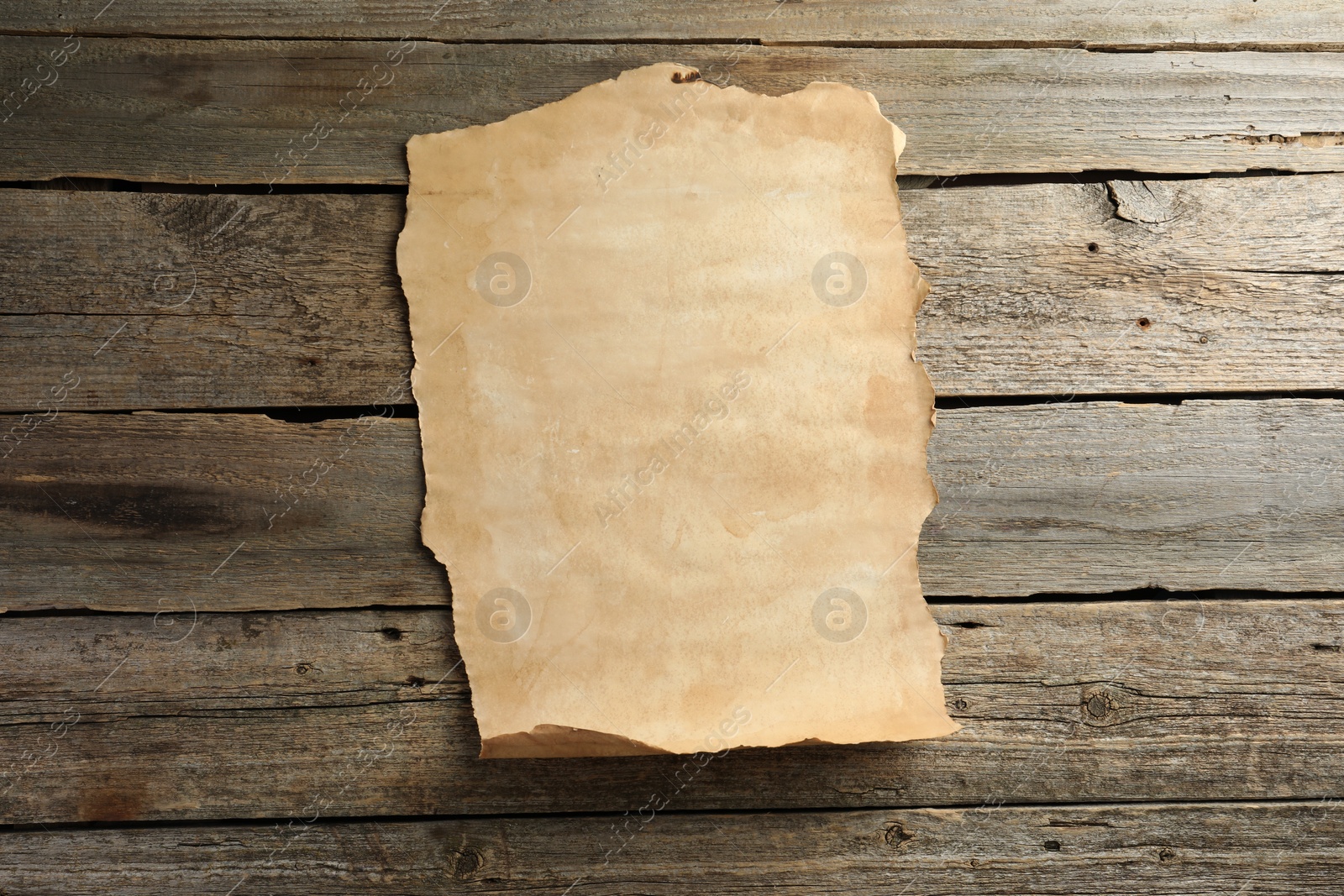 Photo of Sheet of old parchment paper on wooden table, top view