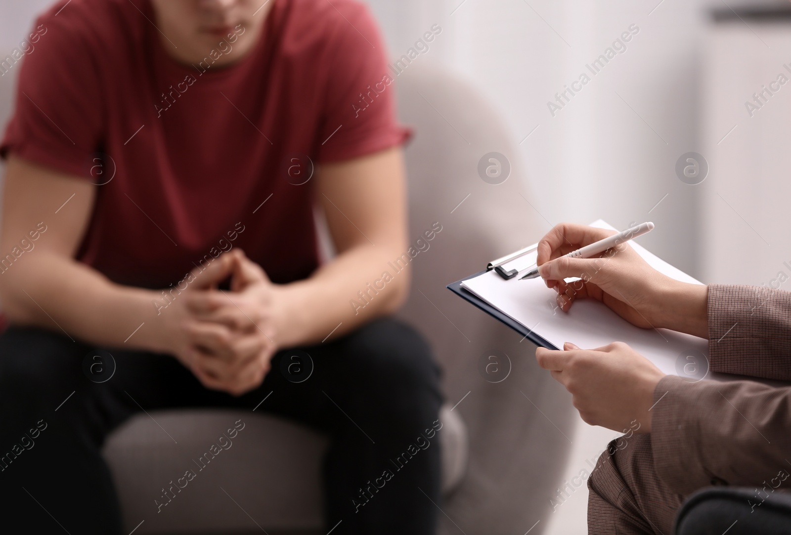 Photo of Psychotherapist working with young man in office, closeup