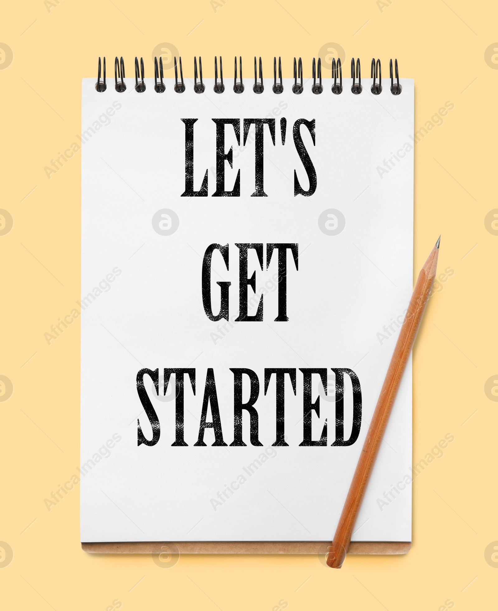 Image of Notebook with phrase LET'S GET STARTED on yellow background, top view