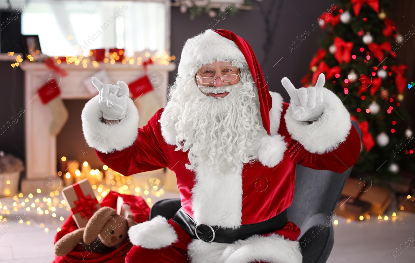 Photo of Authentic Santa Claus showing funny gestures indoors