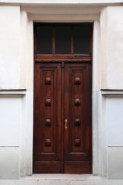 Entrance of house with beautiful wooden door and transom window