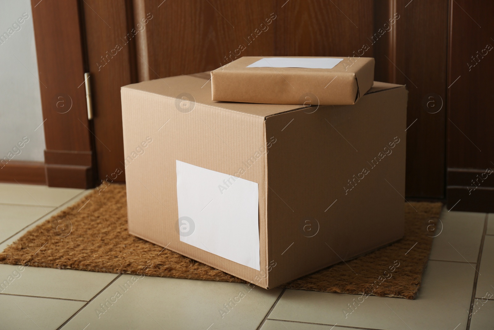 Photo of Parcels on rug near door. Delivery service