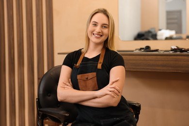 Portrait of professional hairdresser wearing apron in beauty salon