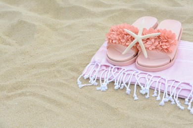 Photo of Blanket with stylish slippers and starfish on sand outdoors, space for text. Beach accessories