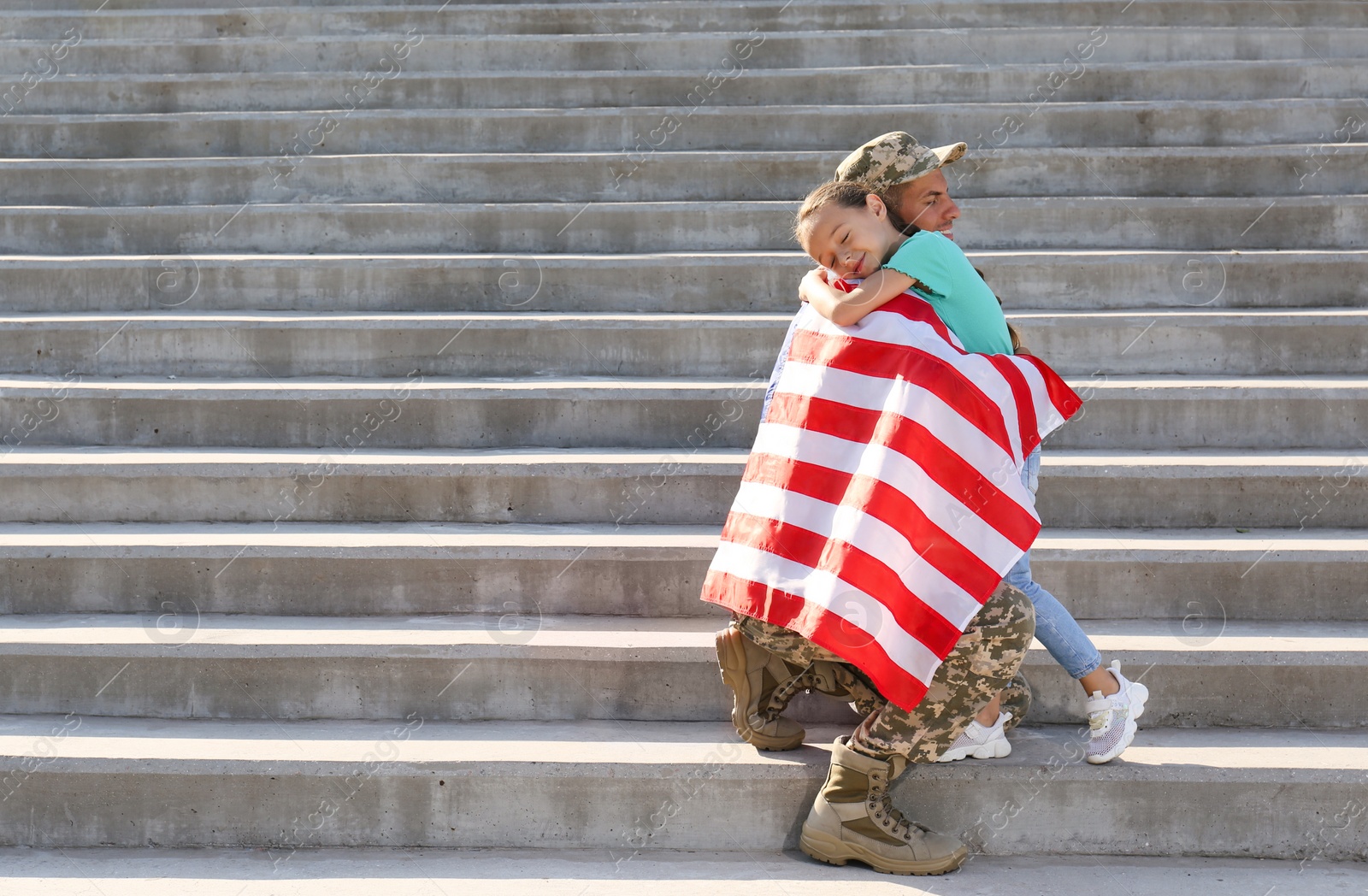 Photo of Soldier with flag of USA and his little daughter hugging outdoors, space for text