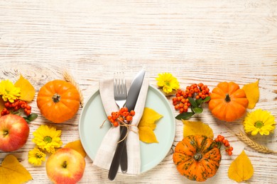 Photo of Flat lay composition with tableware, autumn fruits and vegetables on white wooden background, space for text. Thanksgiving Day