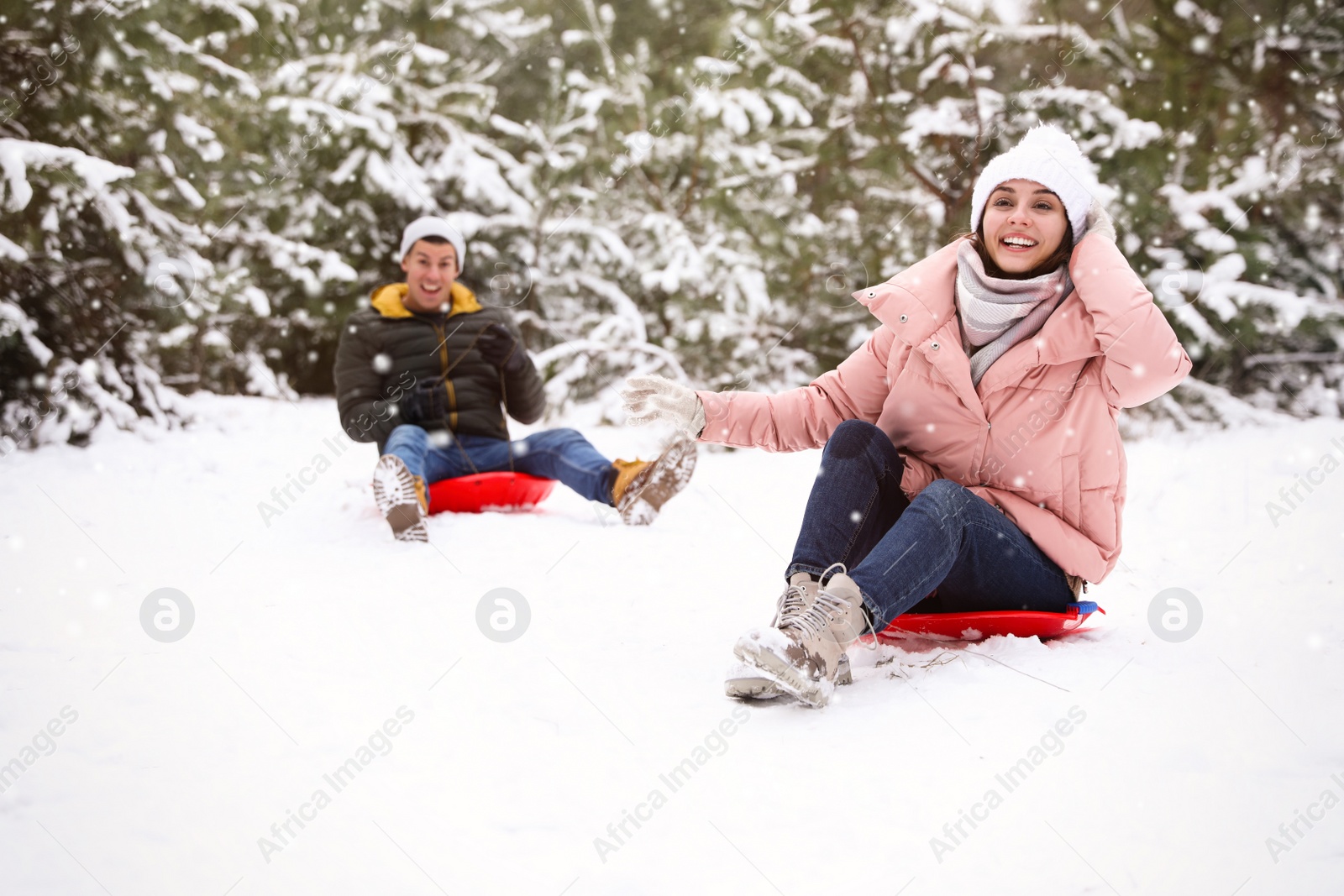 Photo of Happy couple sledding outdoors on winter day. Christmas vacation