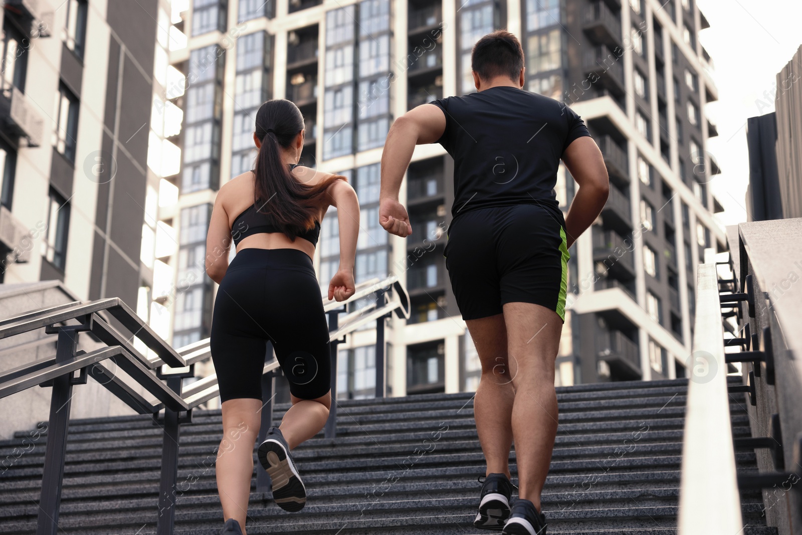 Photo of Healthy lifestyle. Couple running up steps outdoors, low angle view