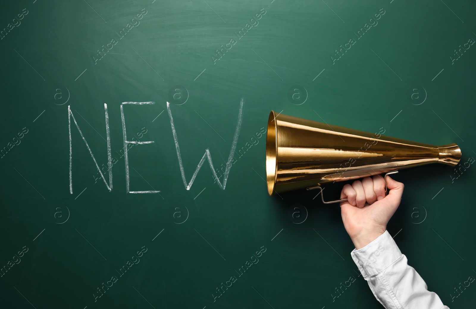 Photo of Man holding megaphone and word NEW on chalkboard