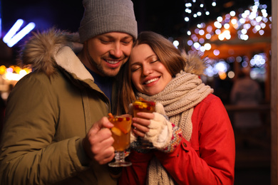 Photo of Happy couple with mulled wine at winter fair