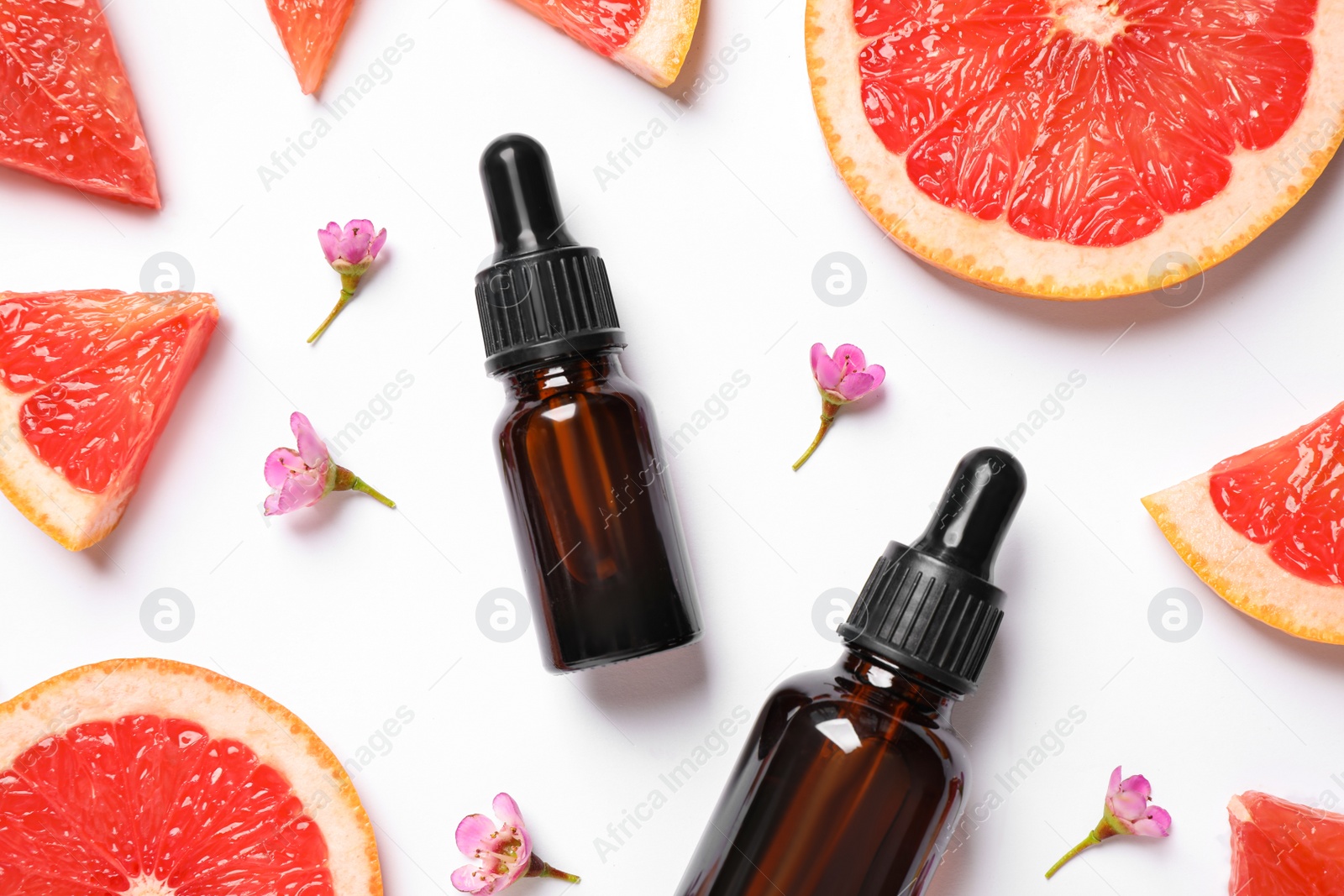 Photo of Flat lay composition with bottles of citrus essential oil on white background