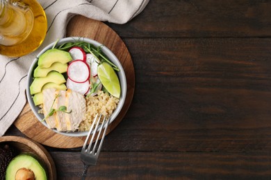 Photo of Delicious quinoa salad with chicken, avocado and radish served on wooden table, flat lay. Space for text