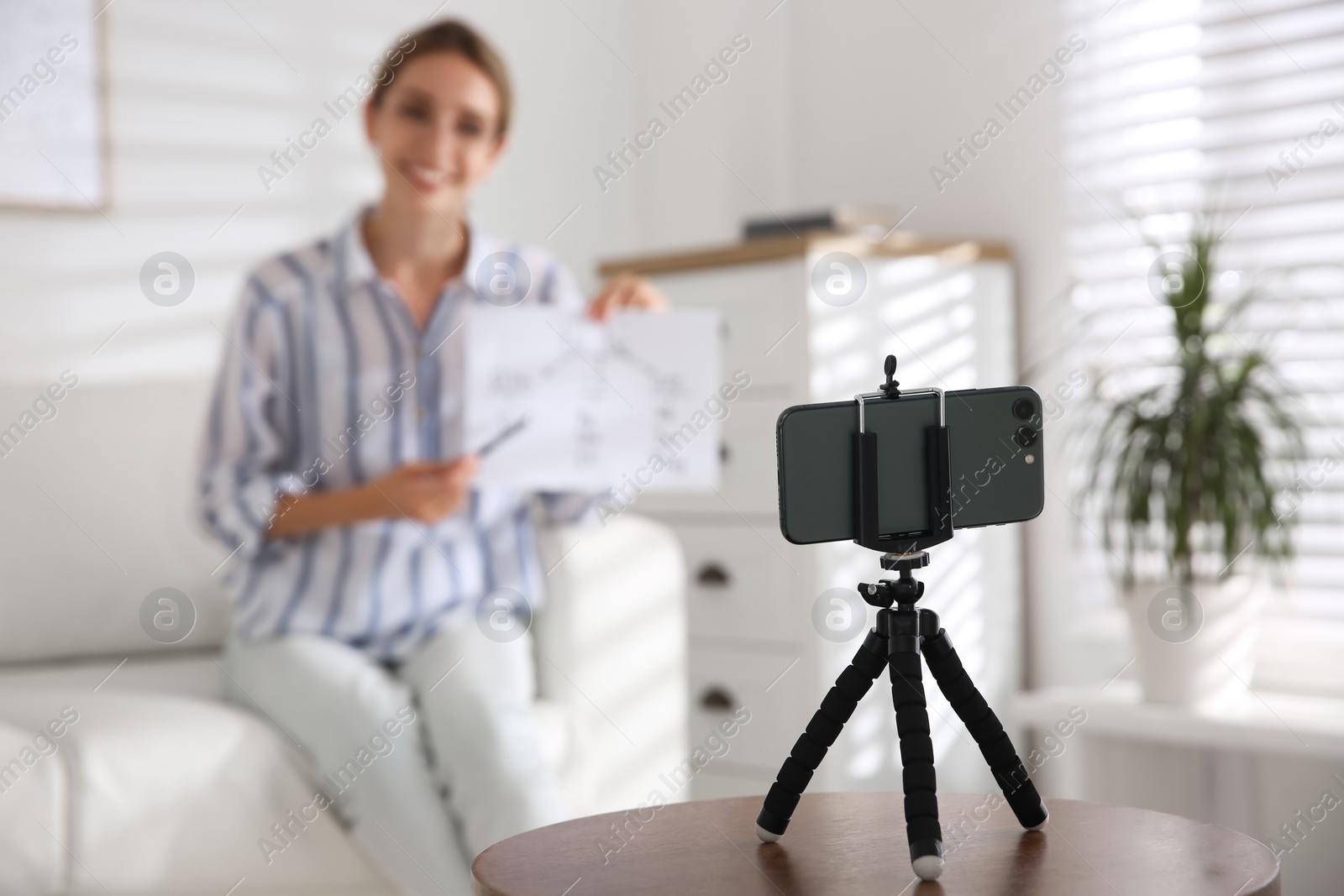 Photo of Teacher giving online school lesson, focus on phone. Distance learning during coronavirus quarantine, study at home