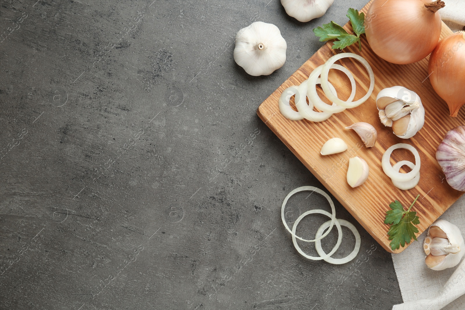 Photo of Flat lay composition with garlic, onions and space for text on grey background