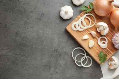 Photo of Flat lay composition with garlic, onions and space for text on grey background