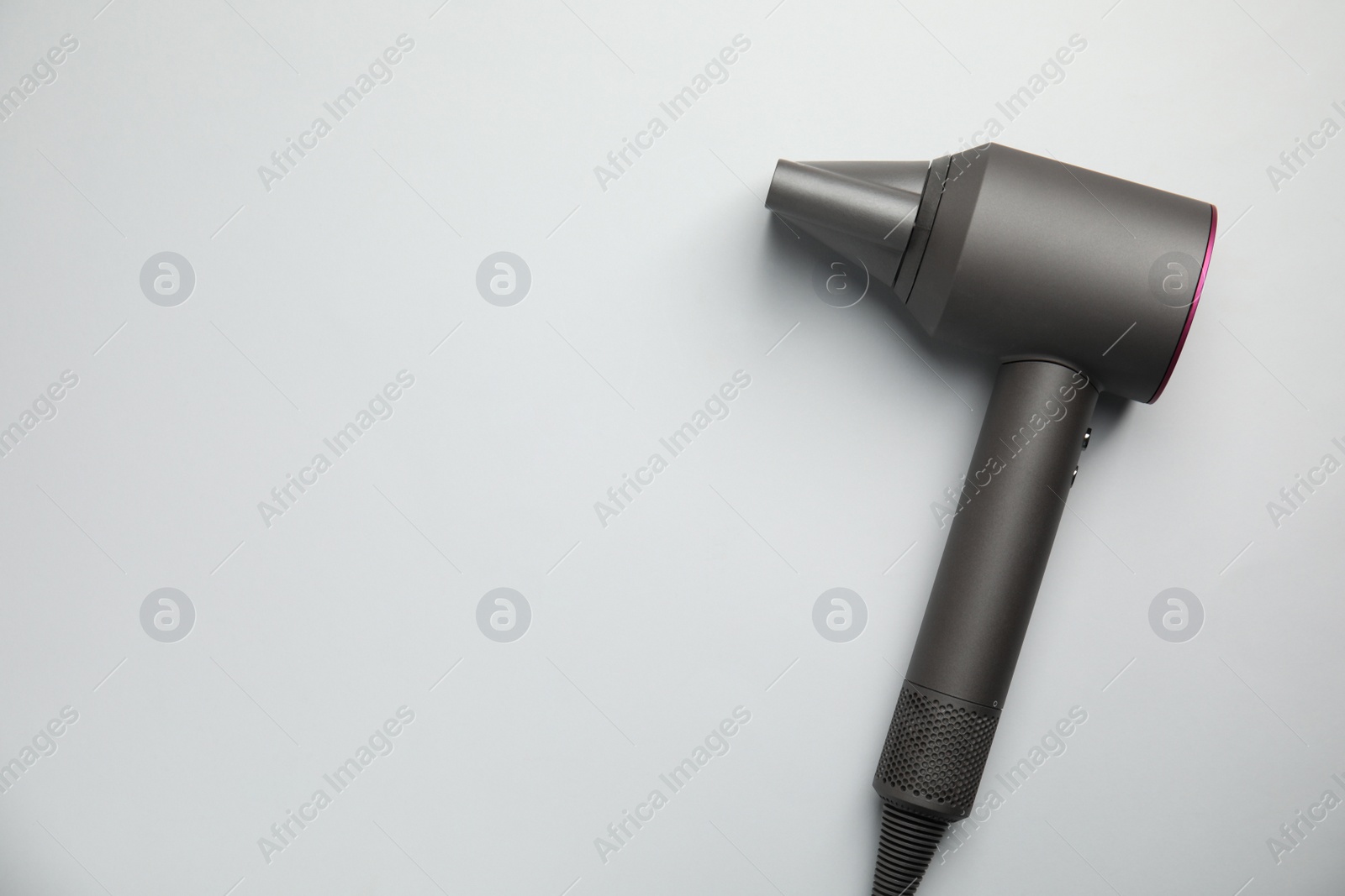 Photo of Modern hair dryer on light grey background, top view. Space for text