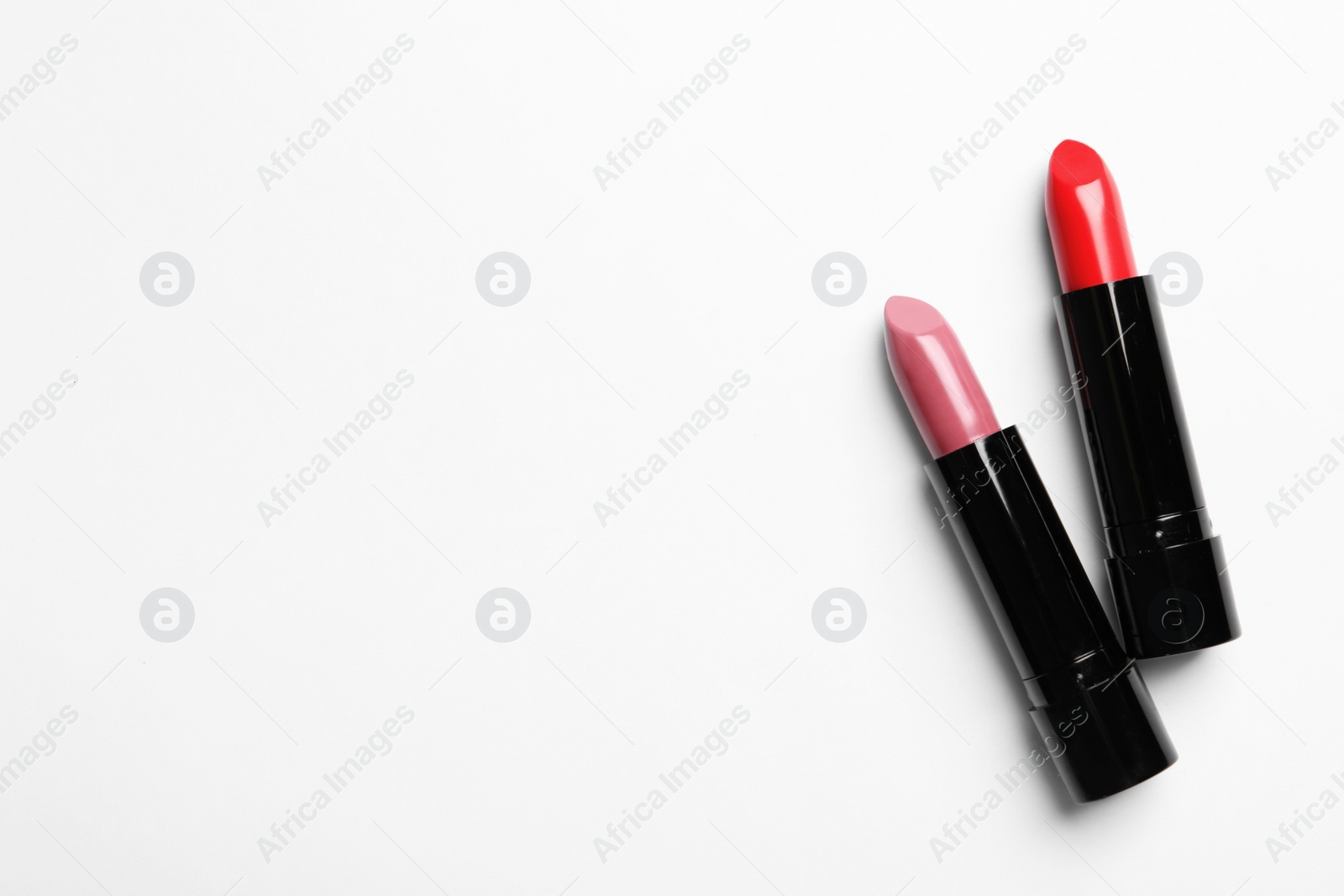 Photo of Different lipsticks and space for text on white background, top view