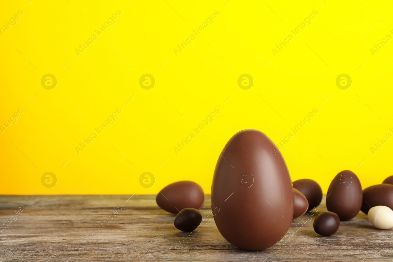 Photo of Beautiful composition with chocolate Easter eggs on wooden table. Space for text