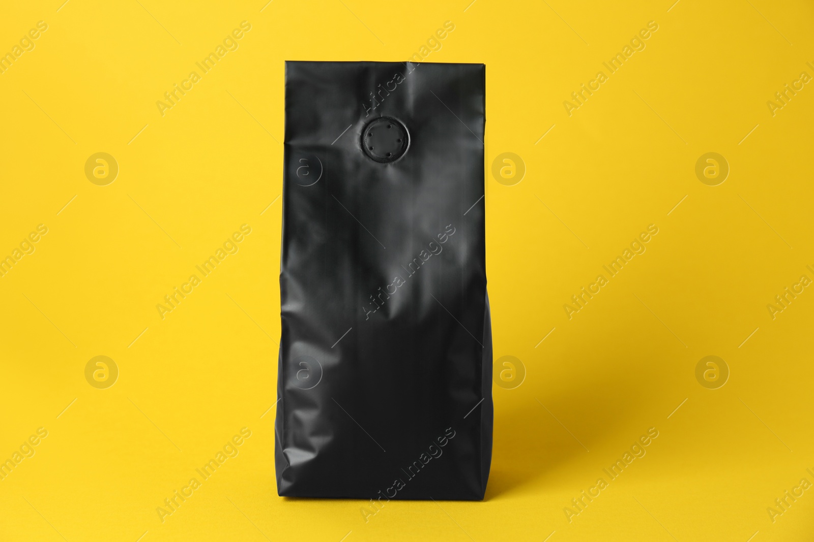 Photo of One blank foil package on yellow background