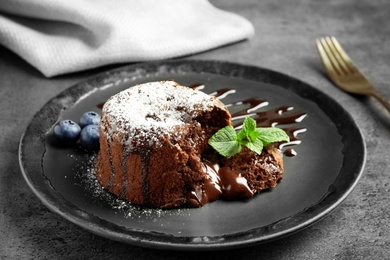 Plate of delicious fresh fondant with hot chocolate and blueberries on table. Lava cake recipe