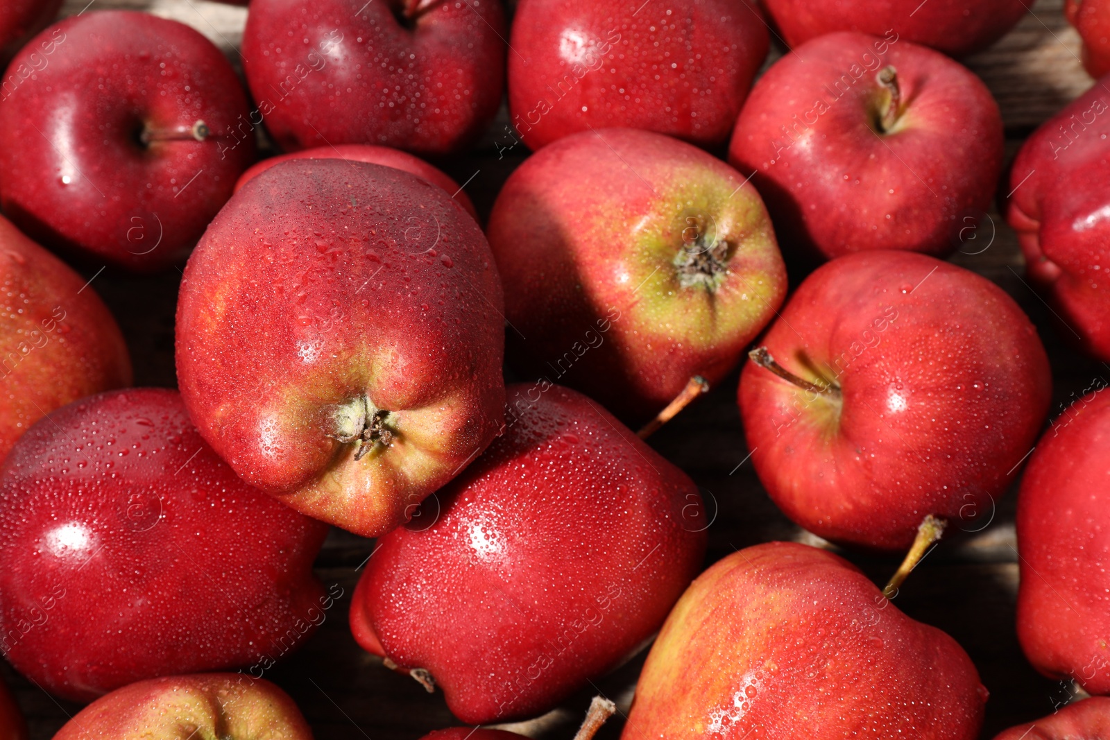 Photo of Many fresh apples with water drops as background, above view